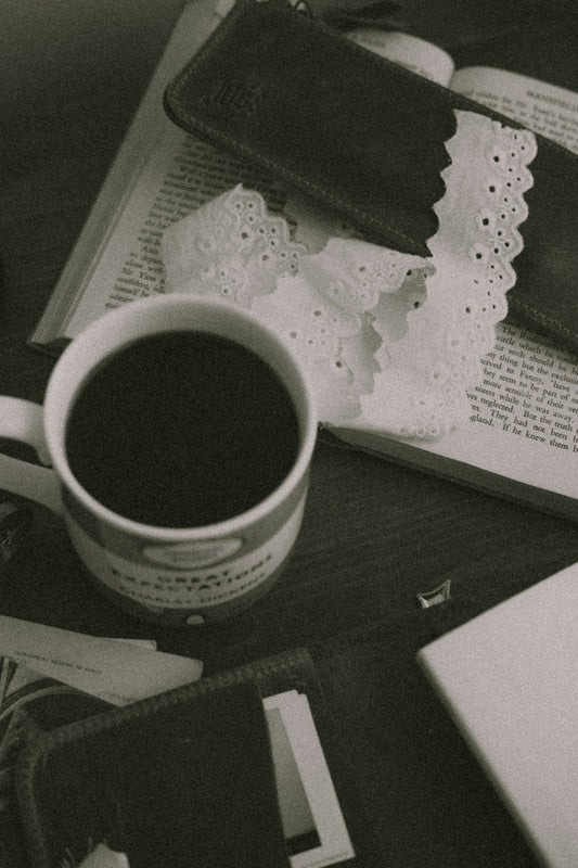 A mug of coffee rests on an open book.