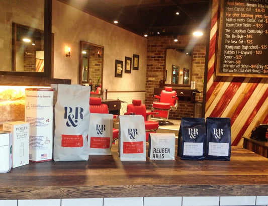 Bags of coffee on a counter in a barbershop.